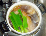 豚の角煮　豚バラ肉ブロックを葱・しょうが・紅茶で煮ている写真